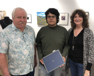 David Cozadd, president of the SFA Friends of the Visual Arts board, and Linda Mock, FVA scholarship committee chair, present the Gary Q. Frields Art Scholarship to Aldo Ornelas, a graduate student in ceramics from Chihuahua City, Mexico.
