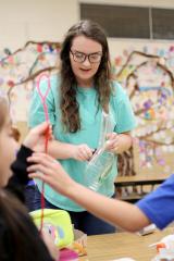 Carolyn Bugg, an elementary education and interdisciplinary studies major at Stephen F. Austin State University, helps students at Raguet Elementary School build an invention during the Novel Engineering project. SFA, Raguet Elementary School and Nibco partnered to bring this literary and engineering project to Nacogdoches. 