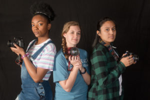 SFA photography students LaShauna Bell, Ashley Spitzmiller and Yared Jasso pose for their own portrait during a lull in the action at Help-Portrait day at Nacogdoches HOPE.